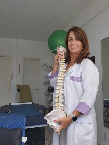 imagem da jenny, de jaleco, segurando uma representação de coluna